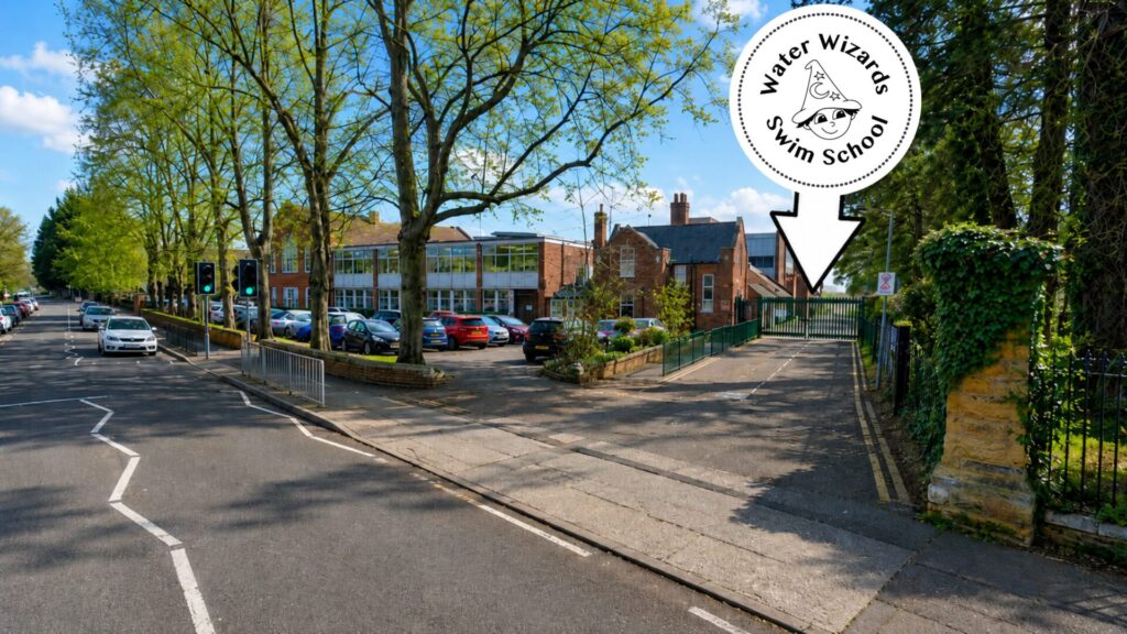 Entrance road to Northampton School for Boys pool, with Water Wizards logo and arrow showing the access road to the pool building.